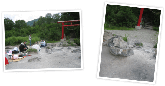 赤い鳥居の前にある腰掛けようの岩の前